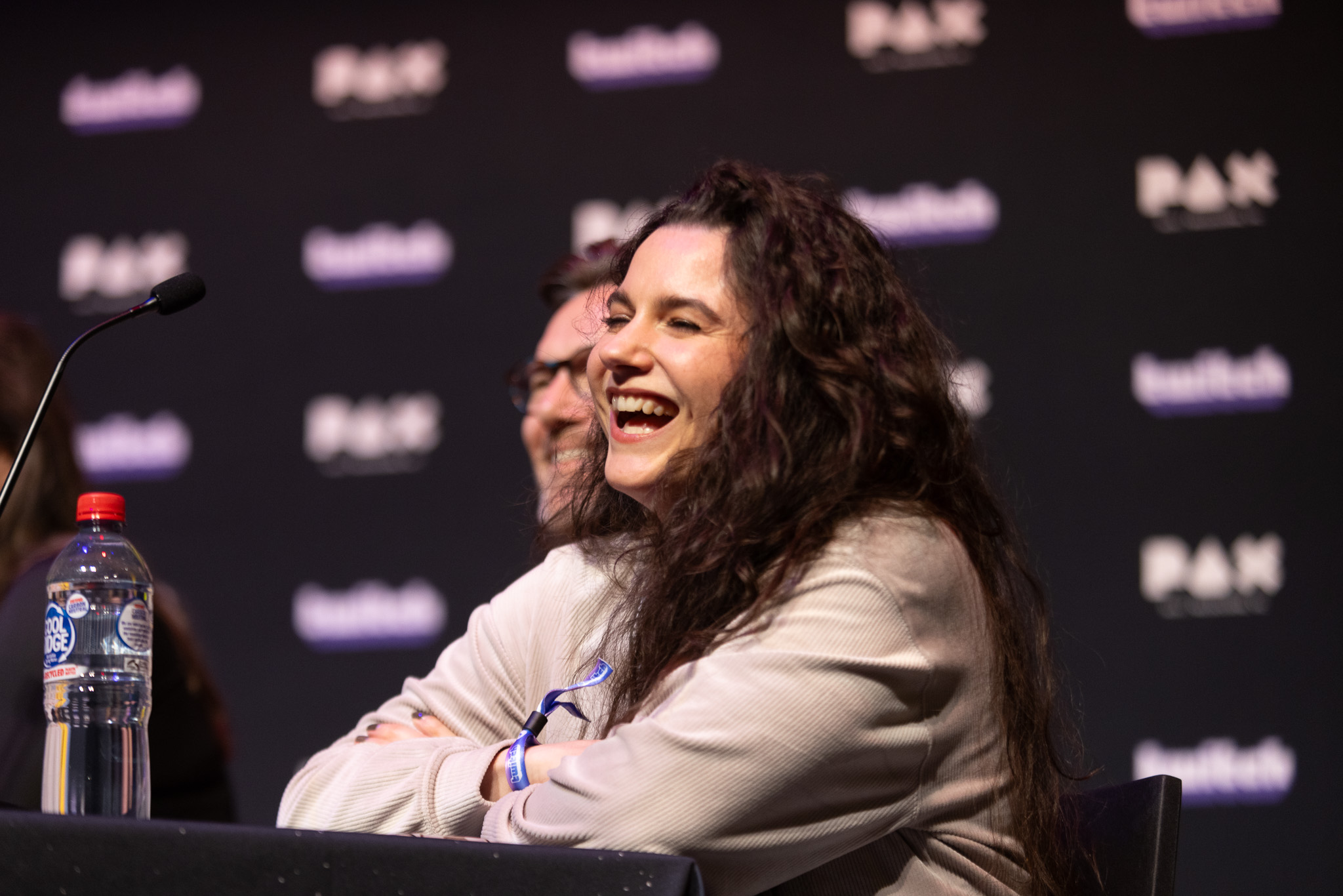 Voiceover artist laughing joyfully at a PAX Australia Panel about voice acting.