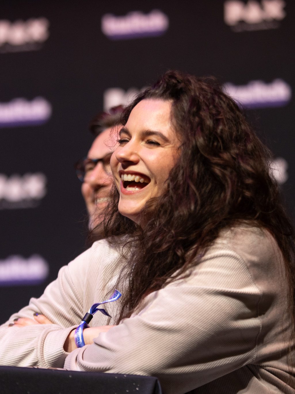 Female voice talent laughing joyfully at a panel at PAX Australia