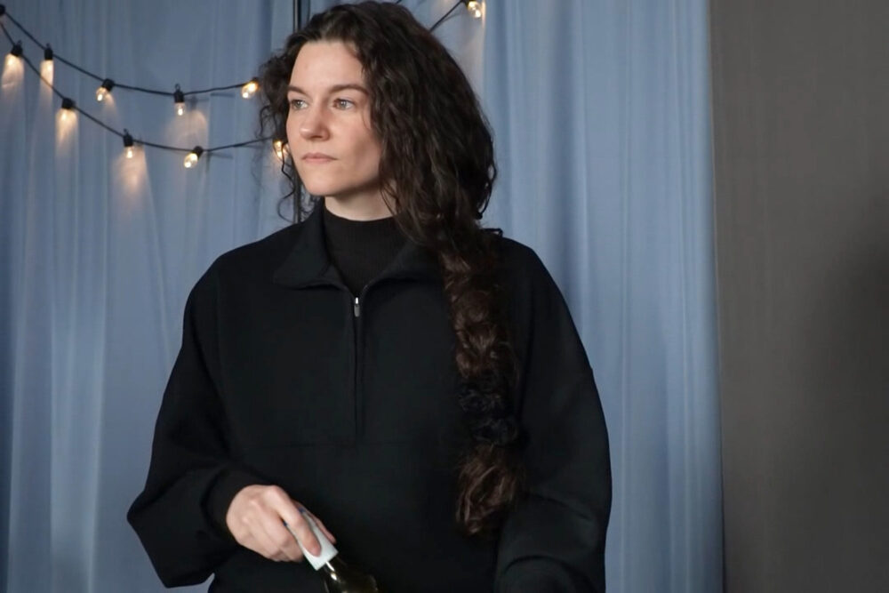 Nina Nikolic in character during a Killing Eve scene study at Hollywood Actor Lab, wearing black against a backdrop of string lights and blue curtains. The dramatic still captures the acting practice and weekly training that became a cornerstone of her performance growth throughout 2025.