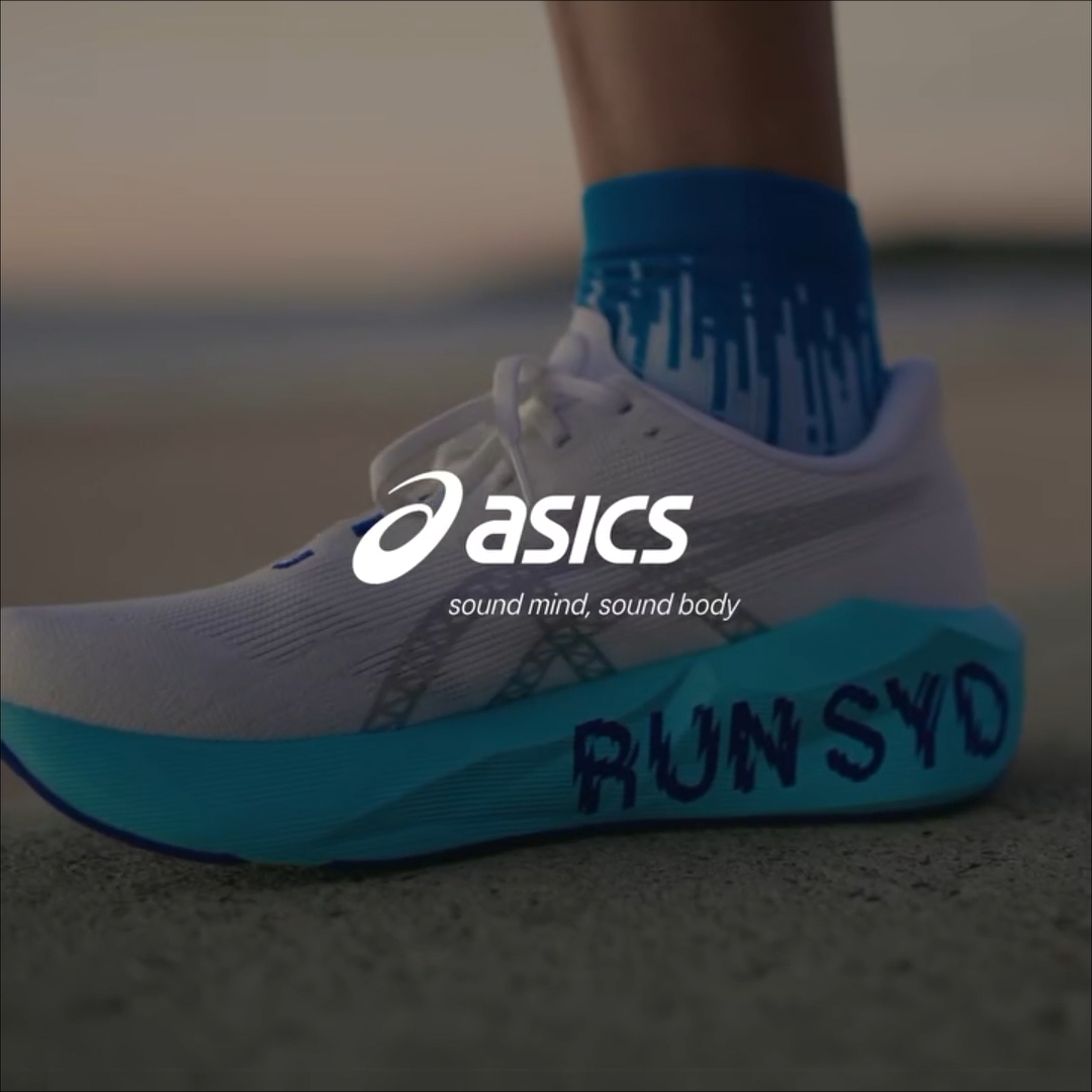 ASICS running shoe in white and turquoise with “RUN SYD” written on the sole, overlaid with the ASICS logo and the text “sound mind, sound body.”